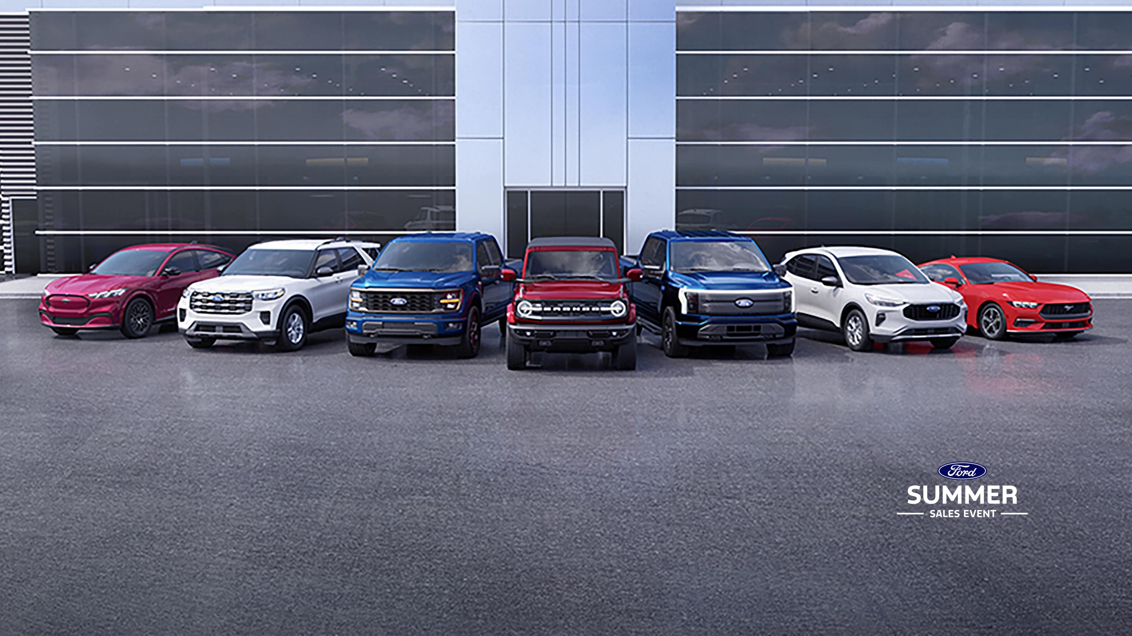 A line-up of Ford vehicles parked in front of dealership building