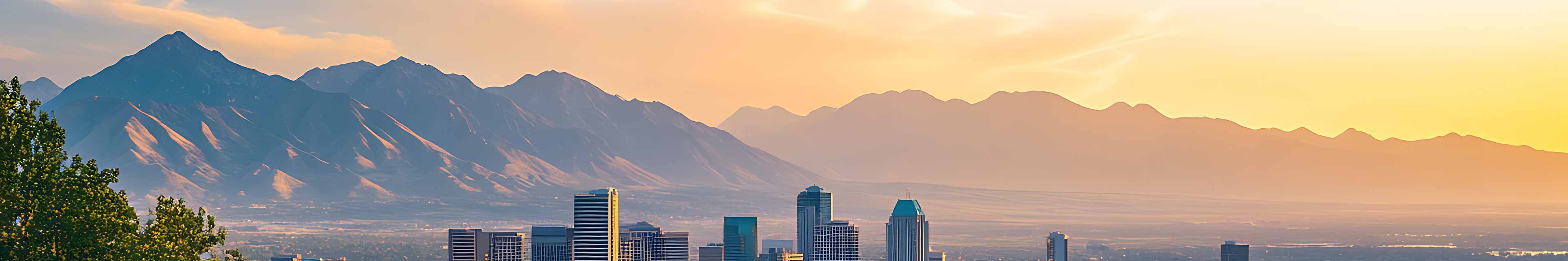 Mountain scene at sunset with buildings in the foreground