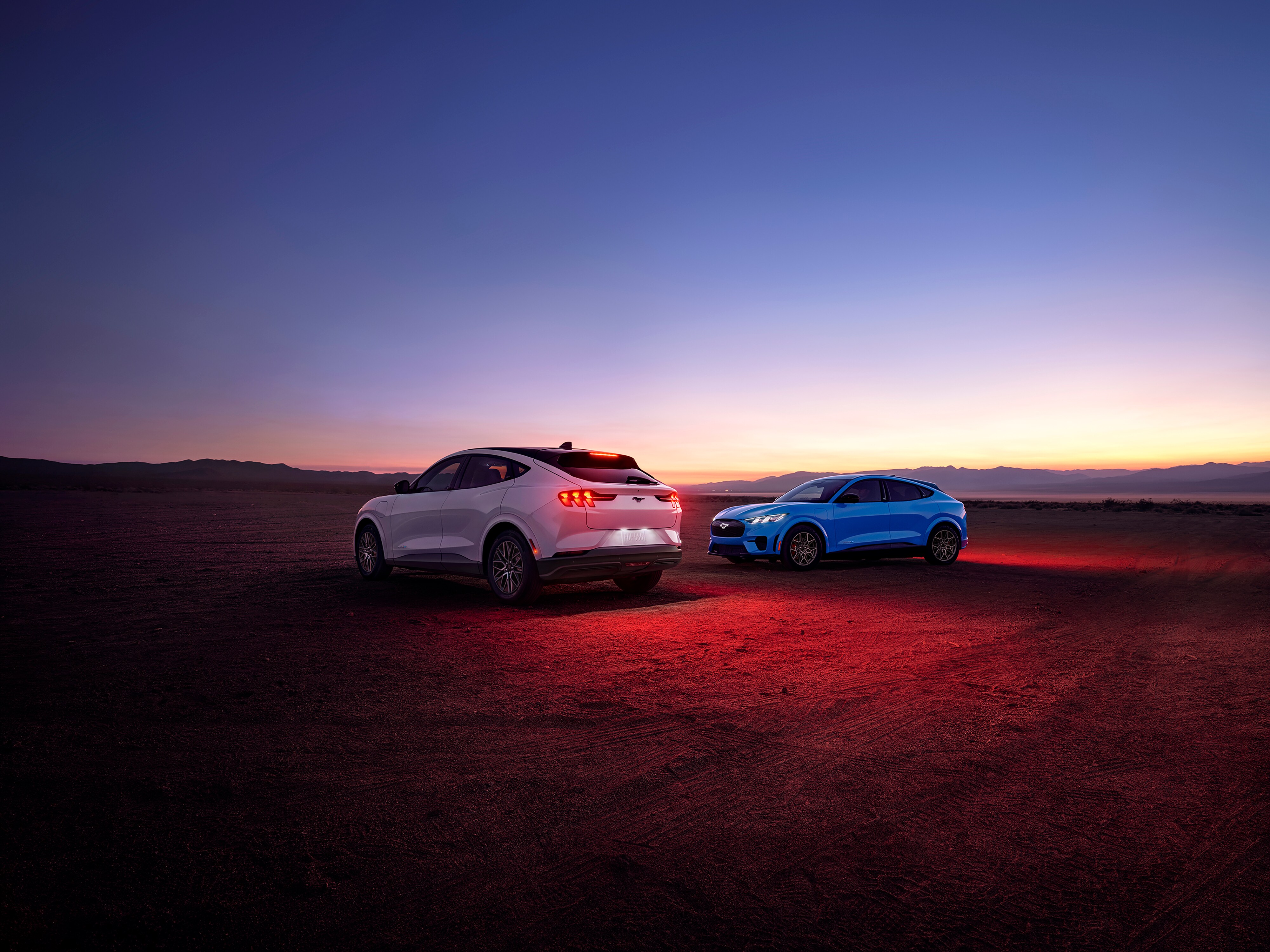 2026 Ford Mustang Mach-E® Premium model (left) and 2026 Ford Mustang Mach-E GT model (right) parked in a desert landscape