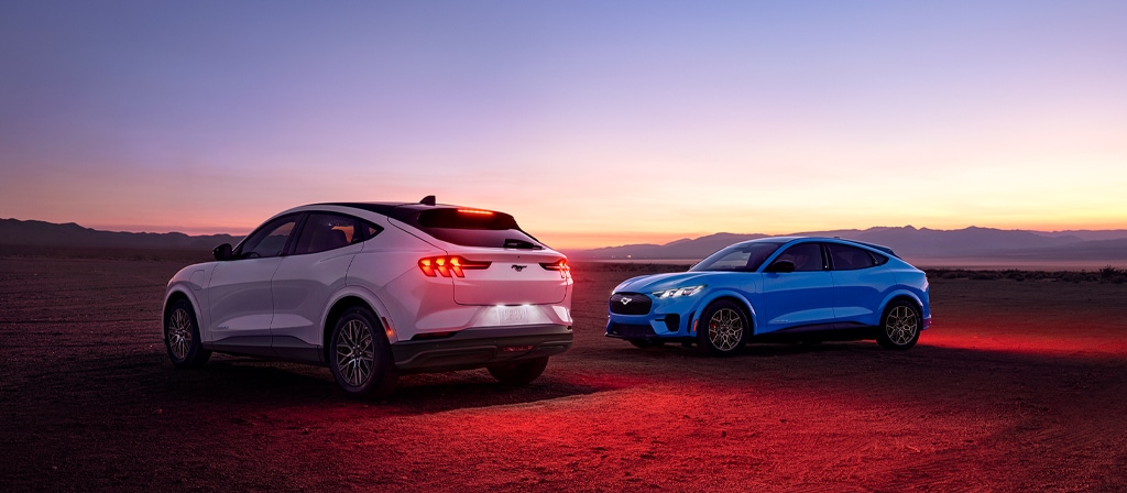2026 Ford Mustang Mach-E® Premium model (left) and 2026 Ford Mustang Mach-E GT model (right) parked in a desert landscape