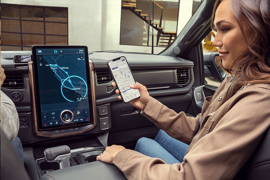 A person with a cell phone in the passenger seat of a 2022 Ford F-150® LightningTM