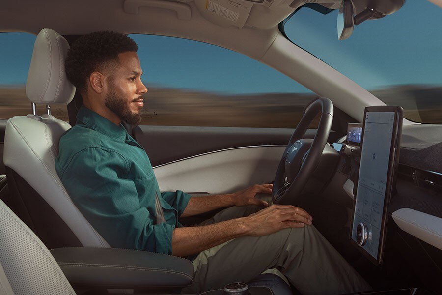 A 2022 Ford Mustang Mach-E® being driven by a person with BlueCruise on a center stack