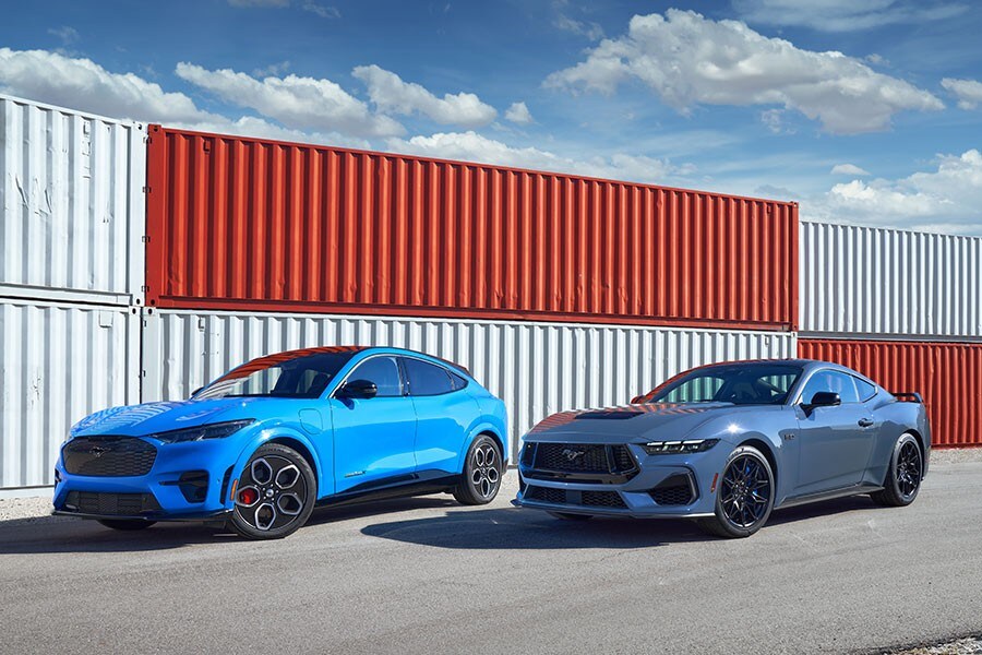 Dos Ford Mustang Coups 2023 estacionadas cerca de contenedores para envío