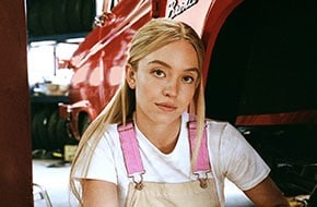 Primer plano de Sydney Sweeney cerca de una SUV Bronco® antigua