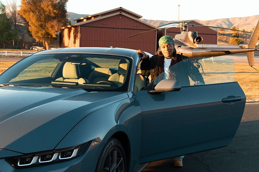 Dee Bryant parada al lado de una puerta abierta de una Ford Mustang® Coupe 2023