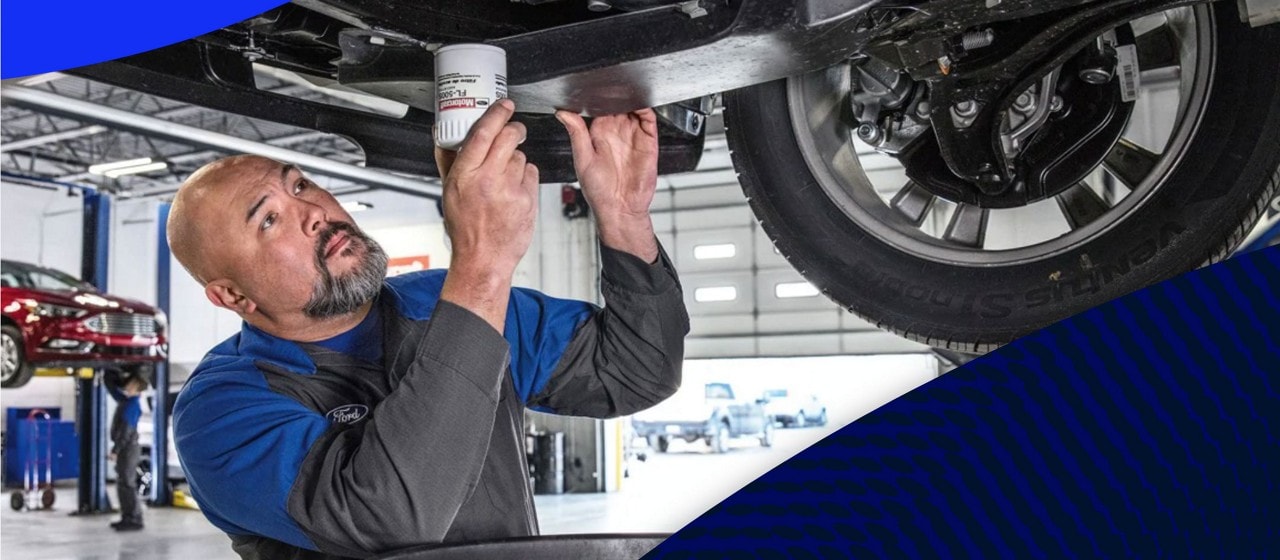 Técnico de un Concesionario Ford cambiando el aceite en un vehículo en un concesionario
