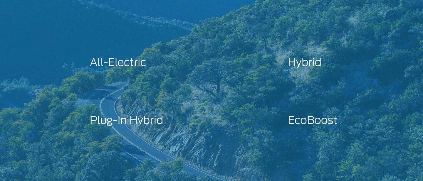 Overhead view of a scenic winding mountain highway surrounded by trees
