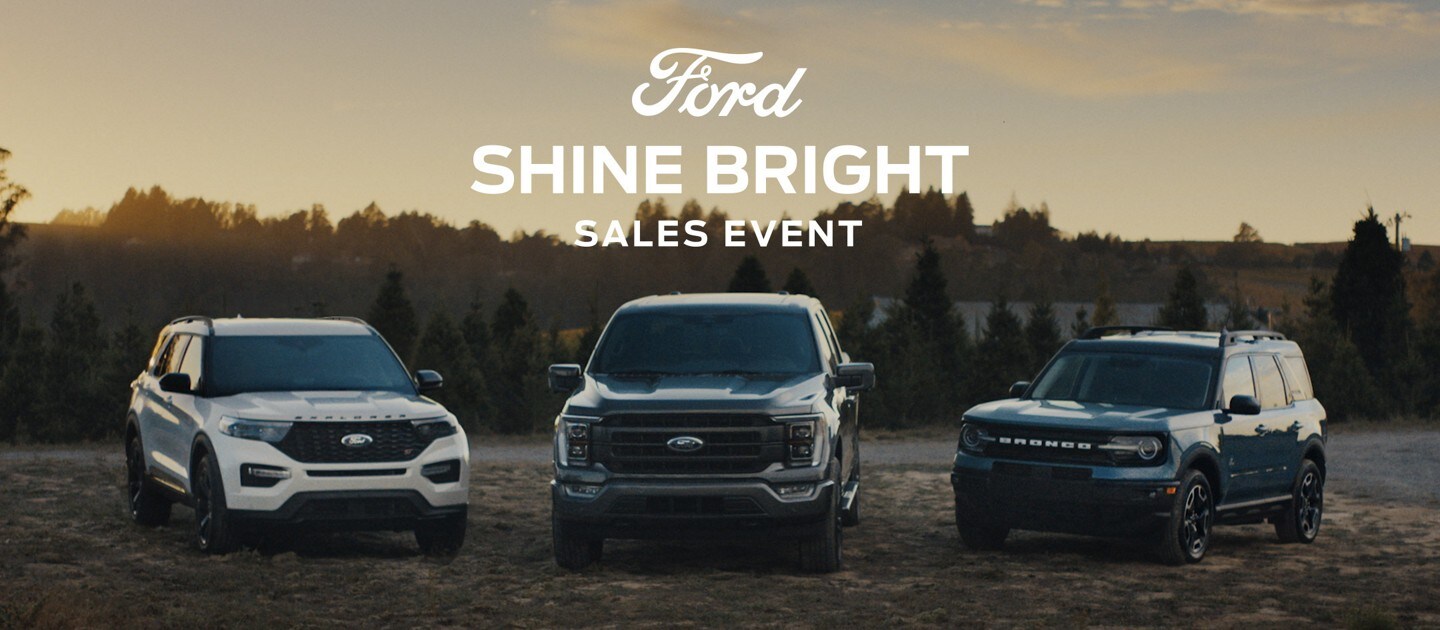 2023 Explorer, 2023 F-150 and a 2023 Bronco lined up with Christmas trees in the background