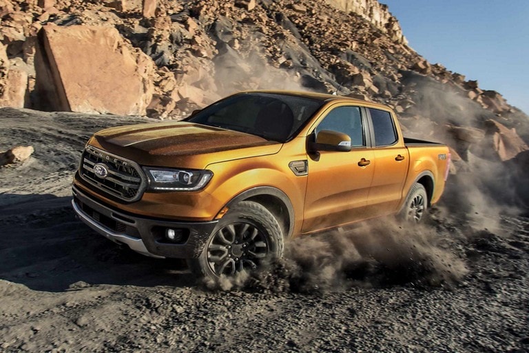 Una Ford Ranger 2022 andando en un sendero todoterreno lleno de rocas, levantando polvo