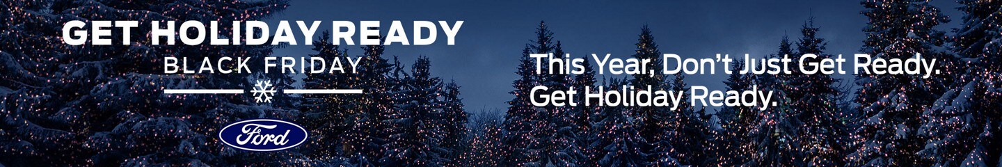 Snow covered pine trees at night with Christmas lights on branches