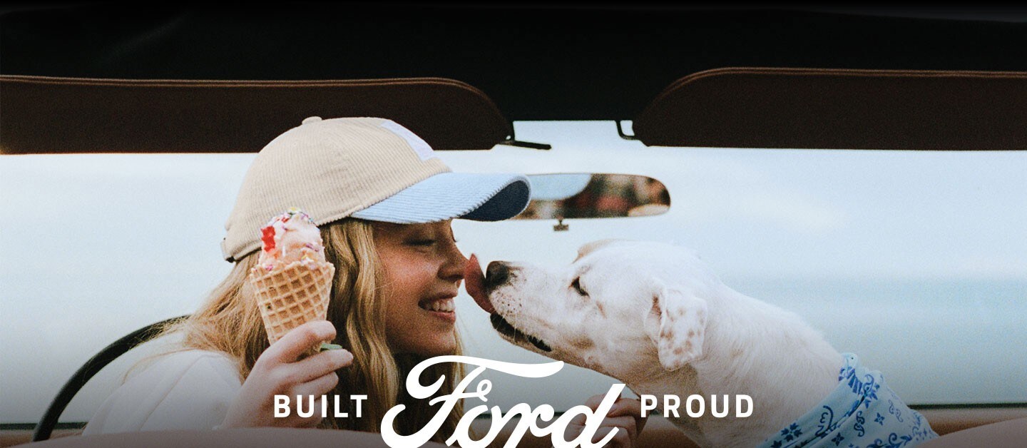 Built Ford Proud logo and Sydney Sweeney parked in her vintage Ford Bronco® SUV with her dog.
