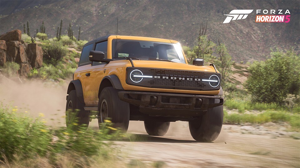 A yellow 2021 Ford Bronco™ Badlands™ being driven down a desert trail in the Forza Horizon 5 video game