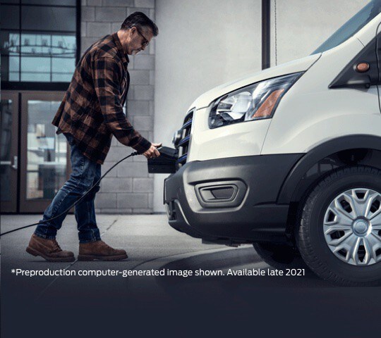 a man plugging a charger into the front of an E-Transit