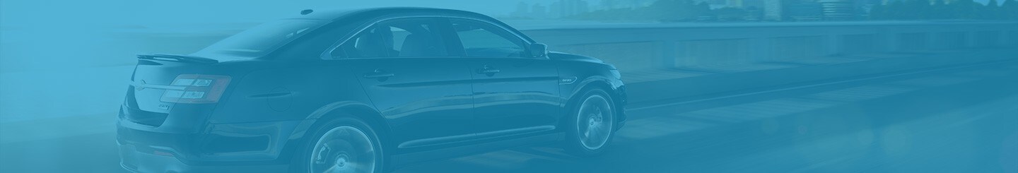 A Ford Taurus being driven down an empty street with a blue overlay on the image
