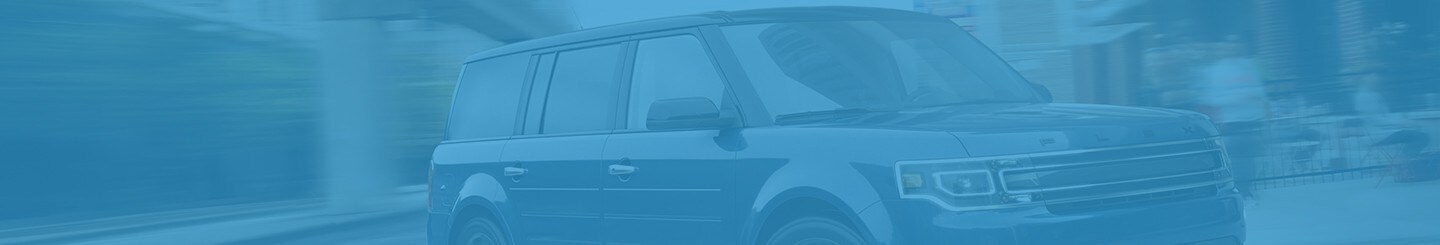 A 2019 Ford Flex being driven on a city street with a blue overlay