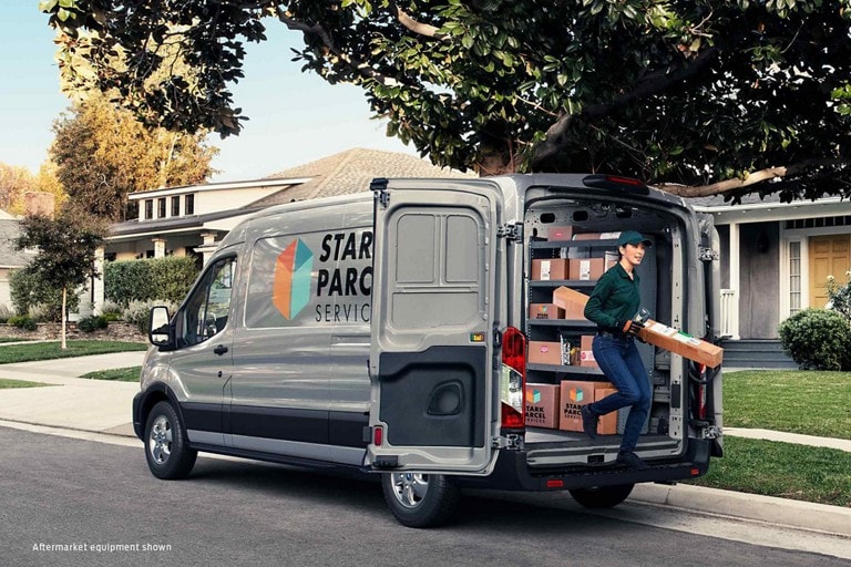 A package is retrieved from the back of a 2020 Ford transit parcel delivery van