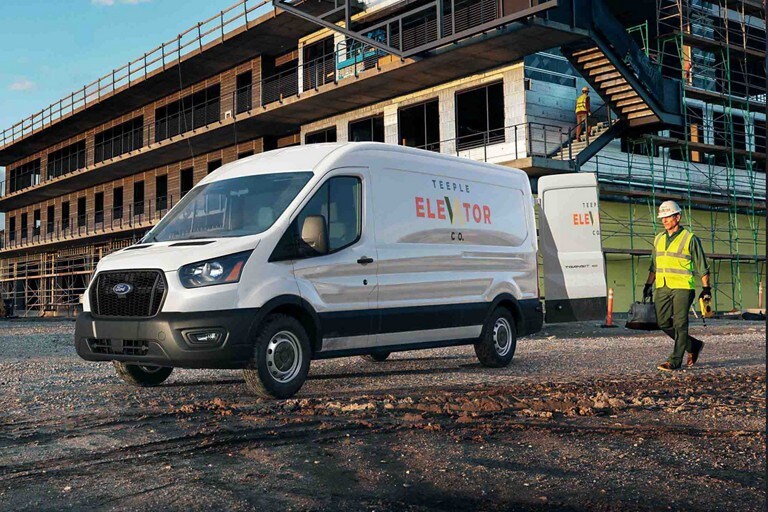A person standing next to a white 2021 Ford Transit Van