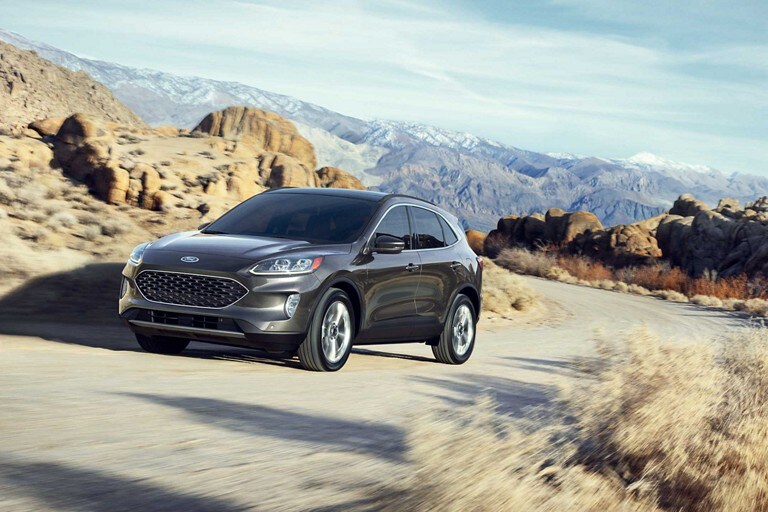 Una Ford Escape Titanium Hybrid 2020 en Magnetic andando por un camino de montaña