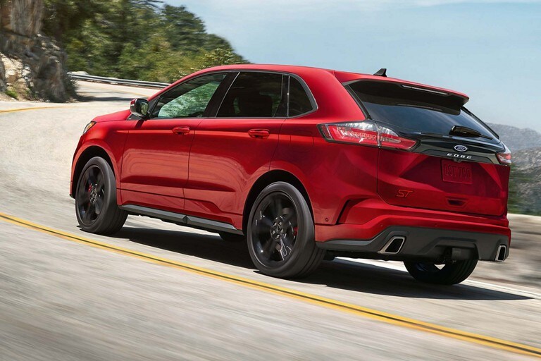 Se muestra una Ford Edge ST 2022 en Rapid Red andando en una carretera pavimentada