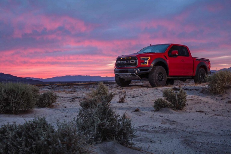 2019 Ford F 150 Raptor Truck Model Highlights Raptor Parked On Sand With Sun Setting In Background