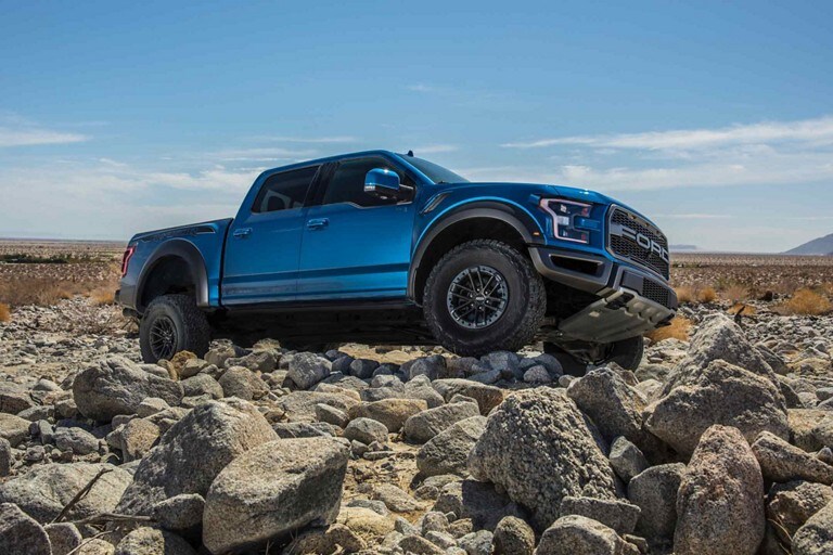 2019 Ford F 150 Raptor Truck Model Highlights Velocity Blue Raptor Parked On A Hill Of Uneven Rocks