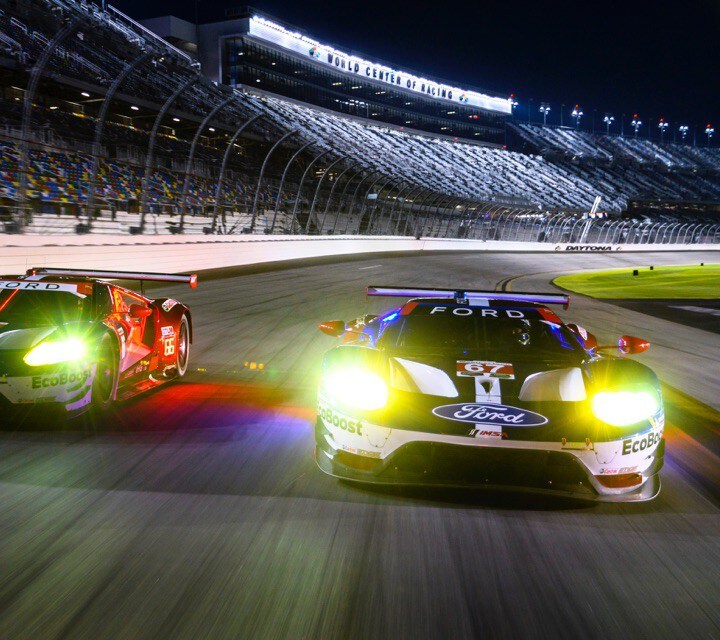 Two Ford G T vehicles on racetrack at night