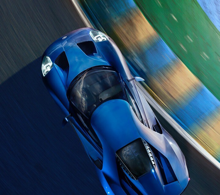 Overhead view of Ford G T rounding corner at Le Mans racetrack