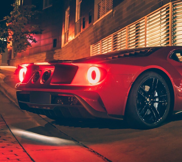 Ford G T pulling into driveway at night