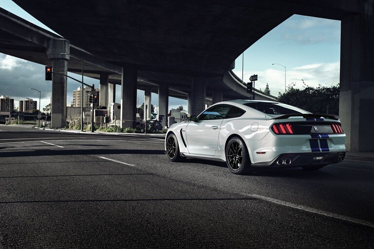 Se muestra el Shelby G T 350 2019 desde la parte posterior mientras pasa debajo de un paso elevado de la autopista