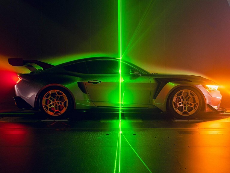Side profile of a parked 2025 Mustang® GTD with a laser beam background