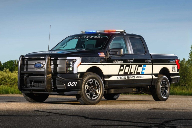 2023 Ford F-150®️ Lightning™️ Pro SSV truck parked with background of trees and bushes
