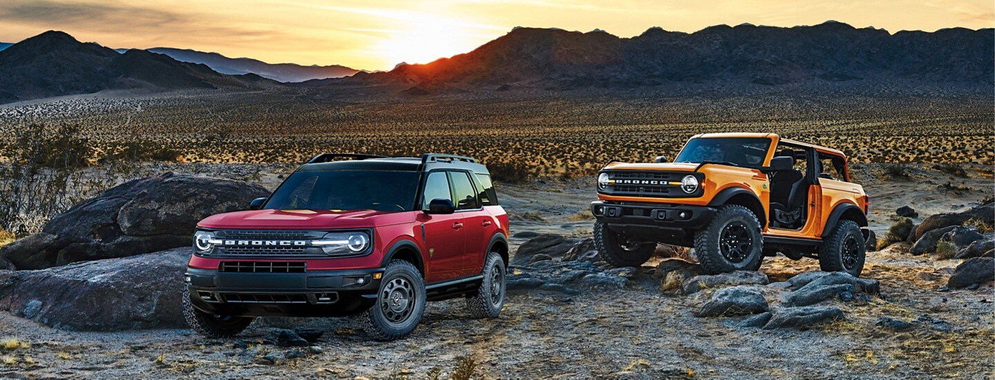 Two Ford Bronco SUVs parked in a desert
