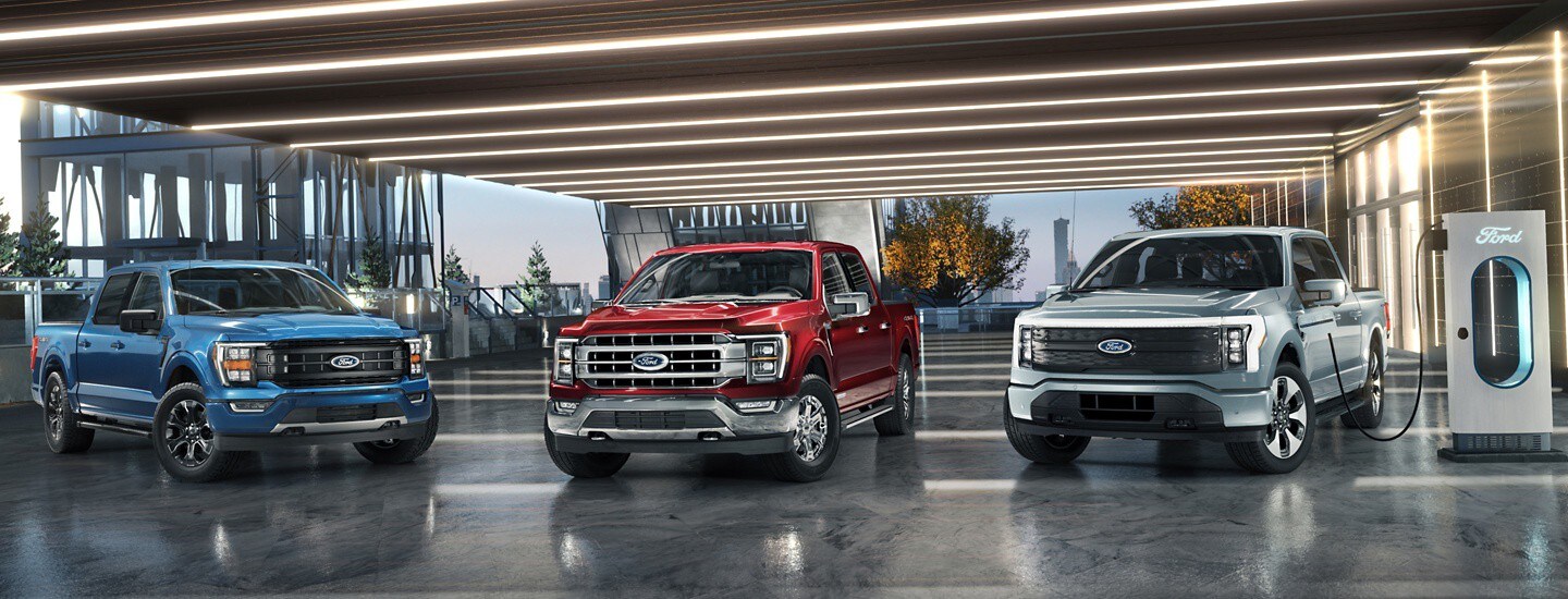 Two different Ford F-150 models are lined up in a desert under blue skies.