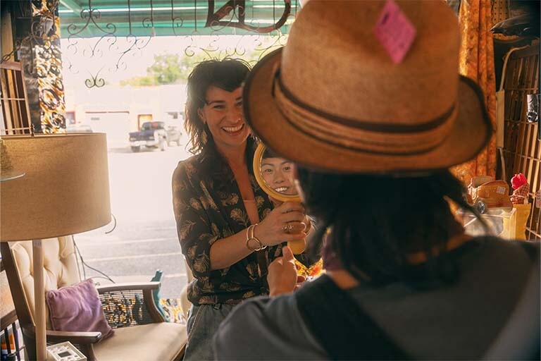 A woman is looking at herself in a mirror.