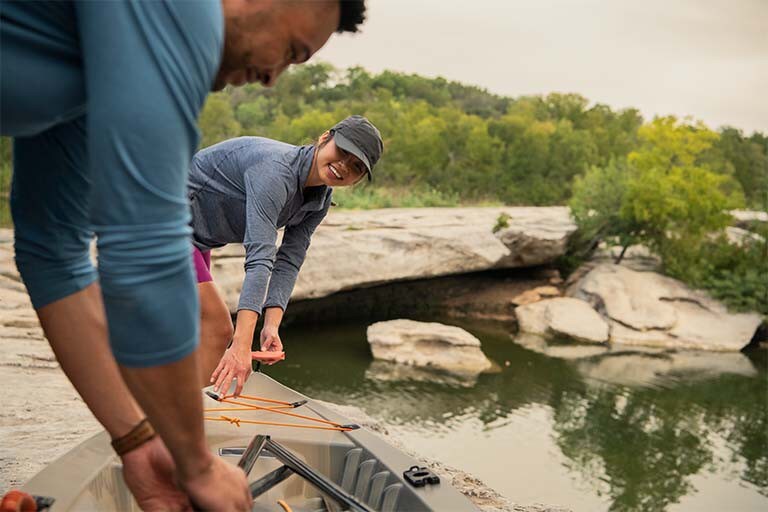 A man and a woman preparing a canoe.