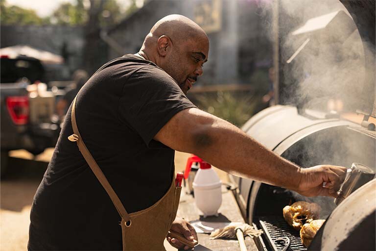 A man is cooking on a grill.