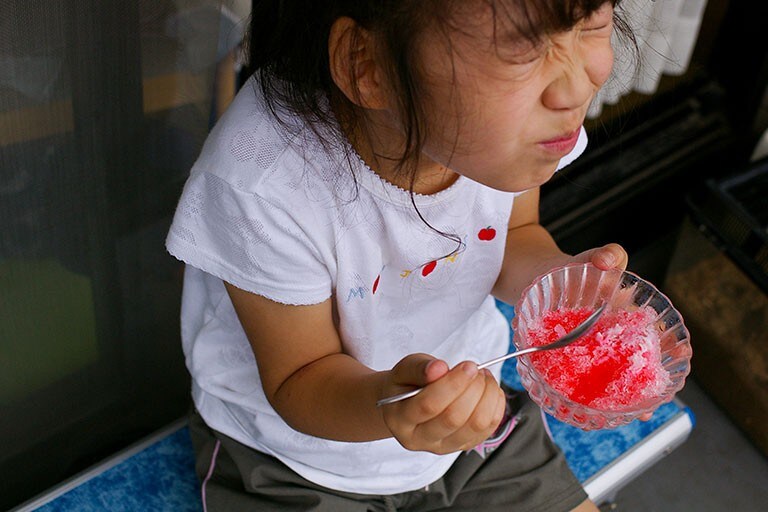Foto de una niña comiendo un postre y sonriendo