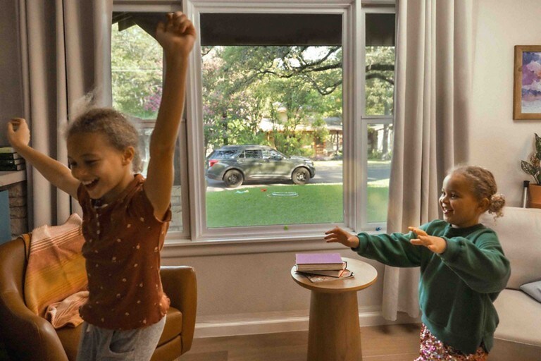 Two kids playing by a window