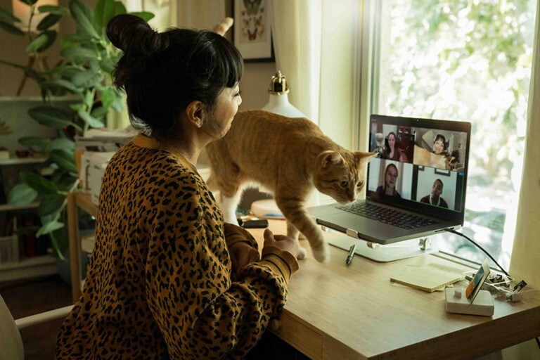 A woman and her cat sitting at a desk