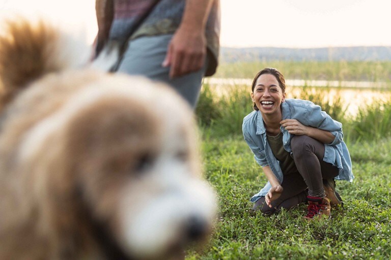 A woman calling to her dog