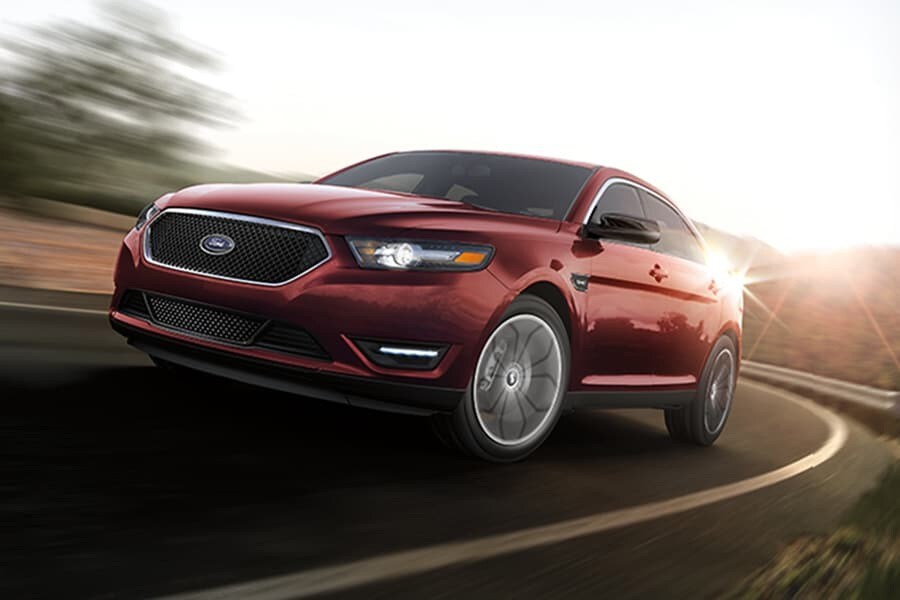 A Ford Taurus being driven around a curve with a blurred background