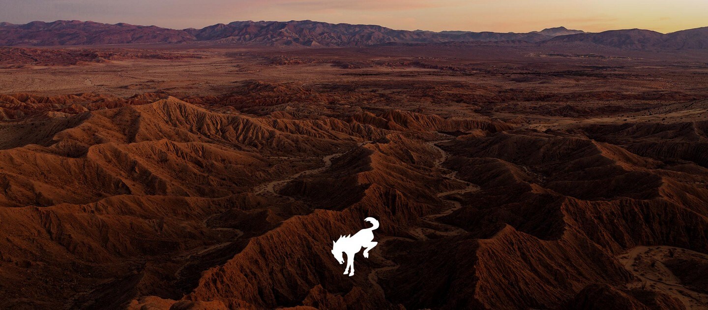 Mountain top with hills of uneven terrain and bronco logo