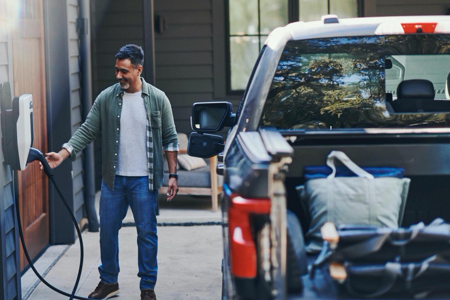 Ford F-150® Lightning® truck being charged in the driveway of a luxury home