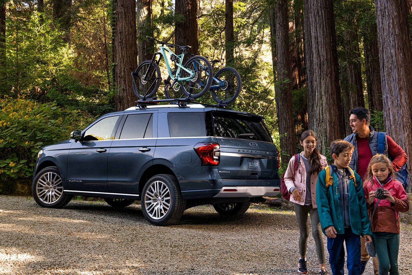 Ford Expedition® SUV in the woods with a family in the foreground