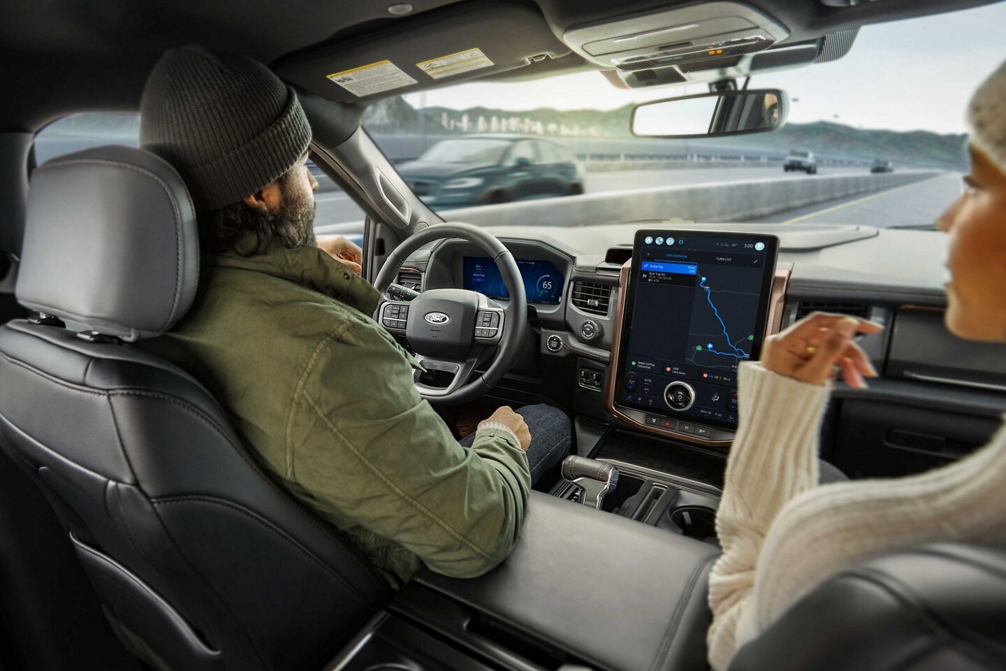 Una pareja en una Ford F-150 Lightning usando BlueCruise en la carretera