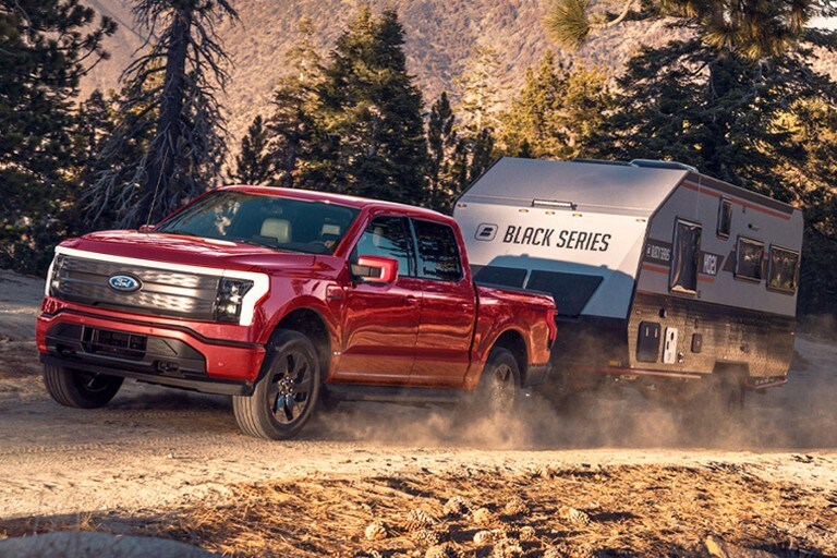 Una camioneta Ford F-150® Lightning™ remolcando una caravana cuesta arriba por una montaña