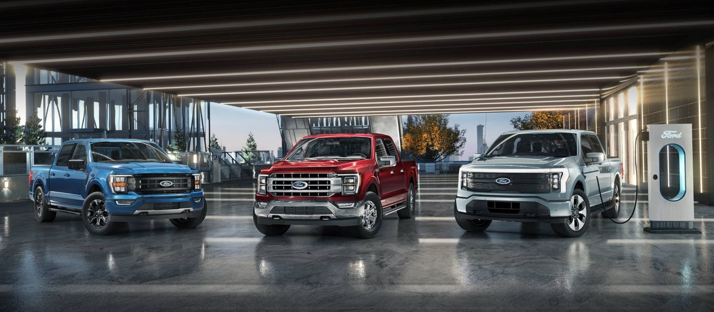 Ford F-150® in Atlas Blue, F-150 PowerBoost™ hybrid in Rapid Red and an F-150 Lightning™ in Iced Blue SIlver