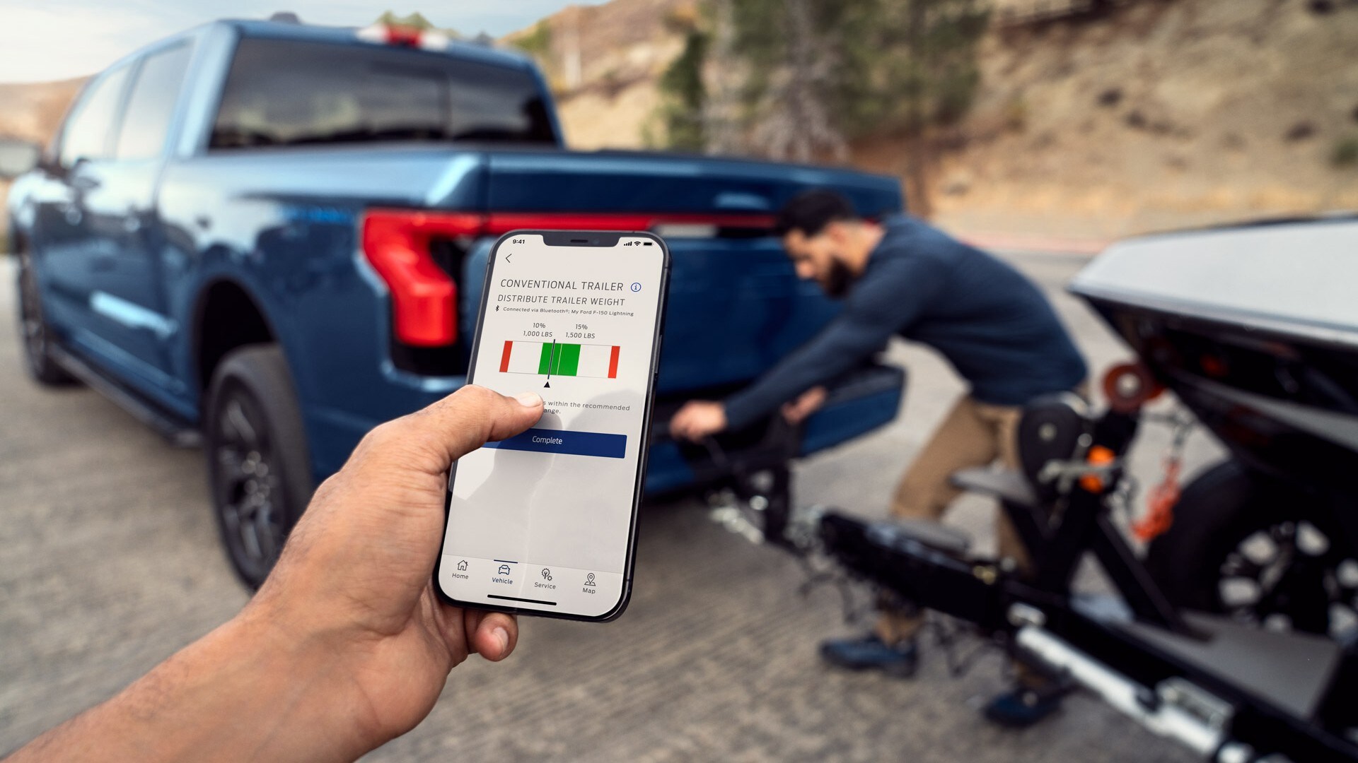 Man checking the weight distribution of his towing load from his smartphone
