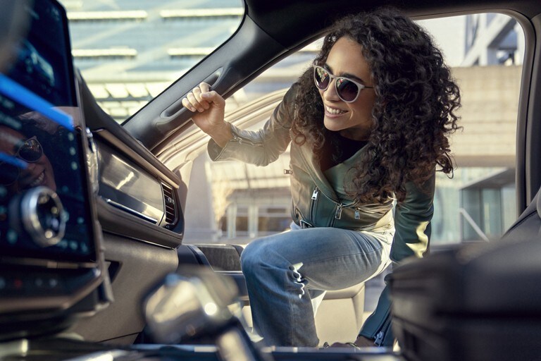 A woman getting into the passenger seat of a 2022 Ford® F-150 Lightning