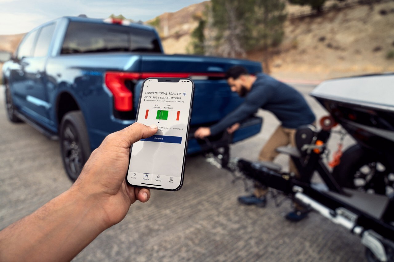 Man checking the weight distribution of his towing load from his smartphone